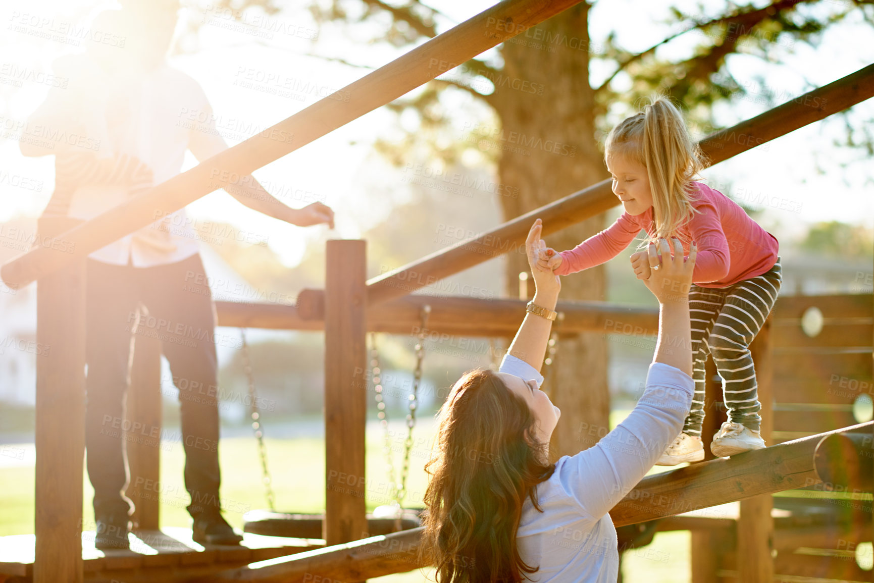 Buy stock photo Playground, happy and parents with kids in park for bonding, playing games and having fun. Family, sun flare and  child for help, mom and dad on holiday, adventure and activity on weekend outdoor