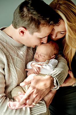 Buy stock photo Forehead, kiss and parents with baby in home for bonding, healthy relationship and love for affection. Family, parenting and embrace with dad, mom and newborn for comfort, trust and security together