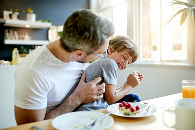 Buy stock photo Breakfast, laugh and father with child in kitchen in home with bonding, happiness and playing. Smile, tickling and dad with boy kid for eating healthy morning meal together with connection in house.