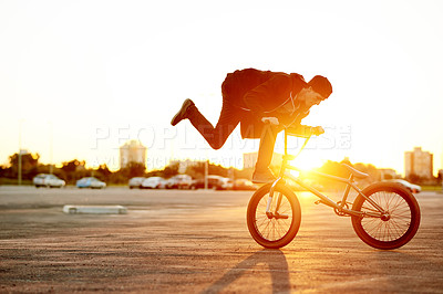Buy stock photo City, sunset and trick with man on bicycle for adrenaline, exercise or extreme sports outdoor. Bike, flare and training with BMX rider on street in urban town for action, balance or hobby practice