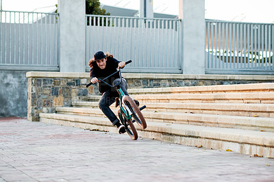 Buy stock photo Man, bike and riding stunt in city with speed for challenge, talent or action outdoor for extreme sports. Skill, trick or  male person for performance, bicycle and energy by steps in urban park