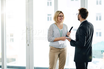 Buy stock photo Teamwork, manager or employee at window with tablet for feedback, communication or project review. Digital app, discussion or business people in workplace with tech, collaboration or strategy meeting