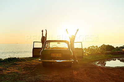 Buy stock photo Shot of two happy young women enjoying a road trip