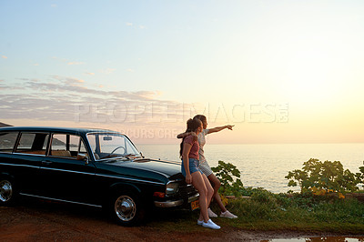 Buy stock photo Shot of two young women enjoying a road trip