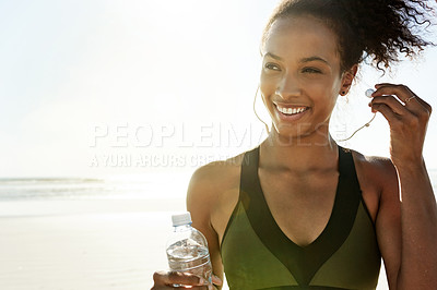 Buy stock photo Woman, earphones and happy at beach for exercise, sky and space with flare for training routine in nature. Person, fitness and runner with music subscription, smile and reflection by ocean in Brazil