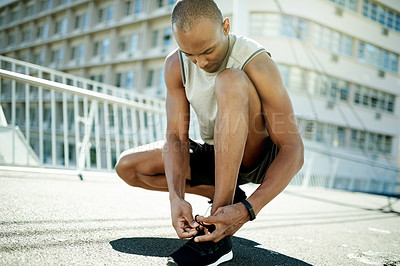 Buy stock photo Black man, tie laces or shoes in city for run, ready or start training with cardio, health and fitness in street. Runner, athlete or person prepare for exercise with sneakers for challenge in town