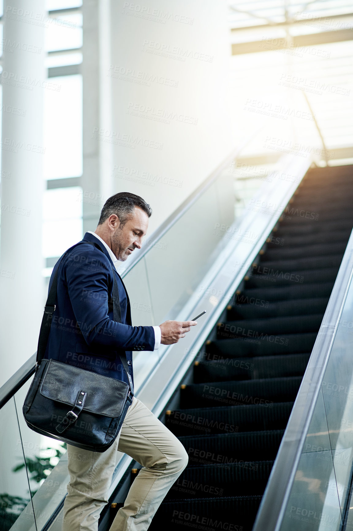 Buy stock photo Escalator, airport and businessman with phone for appointment, commute and arrival in lobby. Mature CEO, professional and person on electric stairs on mobile app for flight schedule, trip or travel