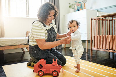 Buy stock photo Mother, baby and walking with help for development in bedroom for growth and bonding. Woman and child together for support, play and care while learning or playing for fun with toys and happiness
