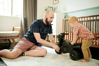 Buy stock photo Father, child and playing with a toy bike in a family home bedroom for fun, growth and development. Man or dad with toddler kid and toys for quality time, bonding and learning together on floor