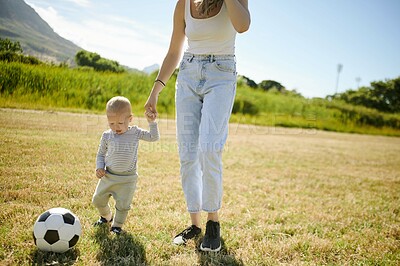 Buy stock photo Baby, soccer ball and a woman playing with her son on a field while bonding together during summer. Kids, love a young mother having fun with her little male child using sports on green grass outside