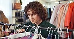 Shopping, option or man in boutique with clothing rack, outfit search or decision in trendy style. Retail, check or customer in store with apparel, garment choice or selection in fashion purchase.