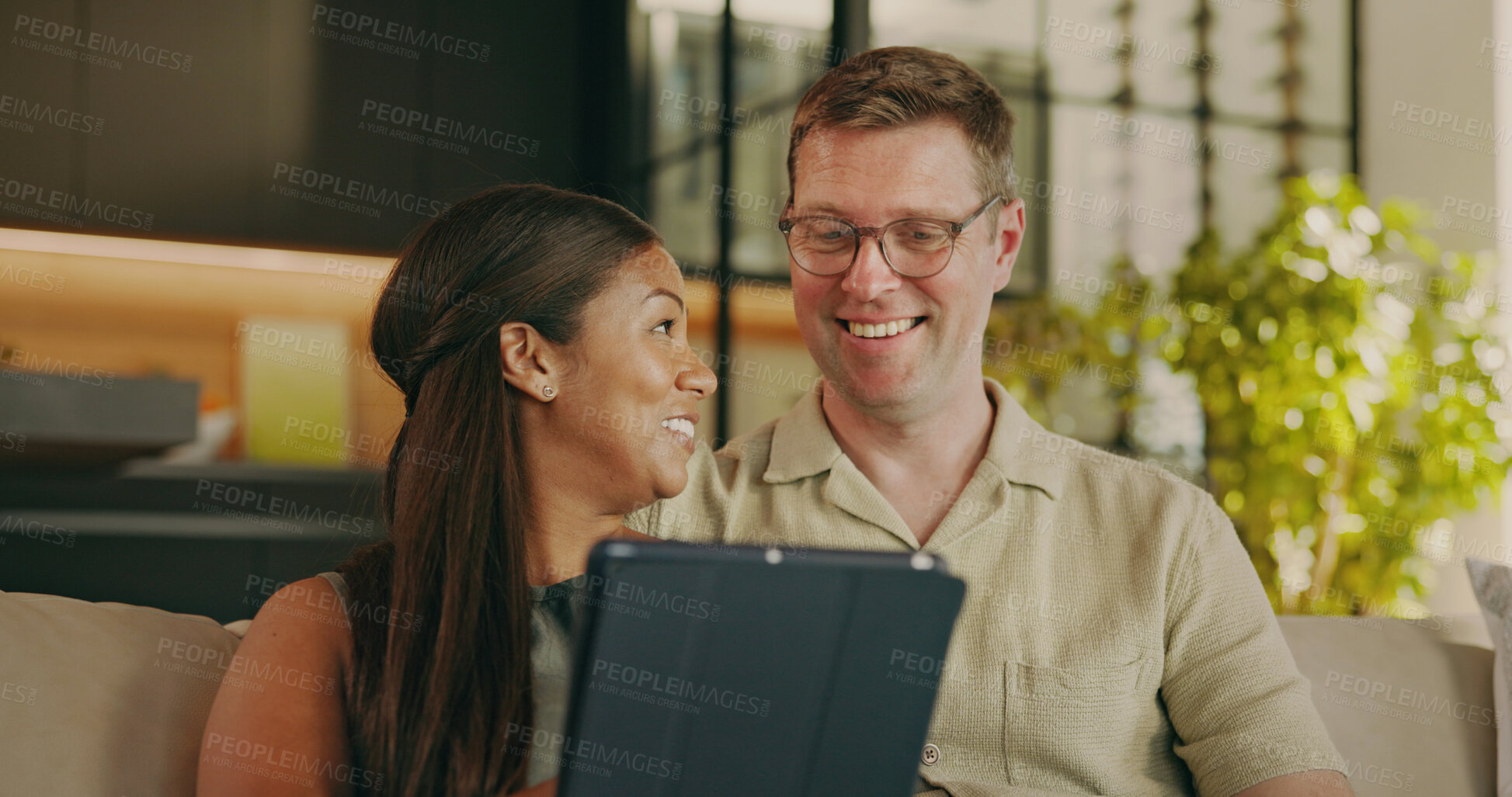 Buy stock photo Relax, love and tablet with interracial couple on sofa for streaming service, bonding and smile. Film subscription, connection and happy with man and woman in living room in home for media app