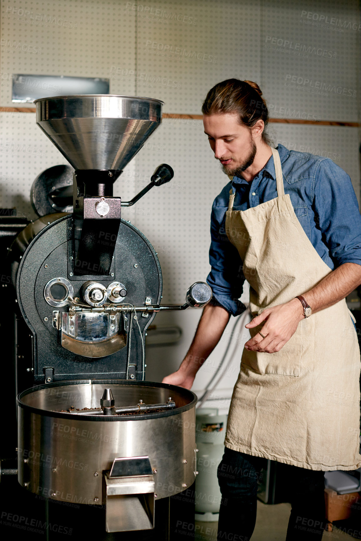 Buy stock photo Ground coffee, machine and roasting with man in kitchen of cafe for preparation of caffeine. Hospitality, service or small business and barista in restaurant with industrial equipment for process