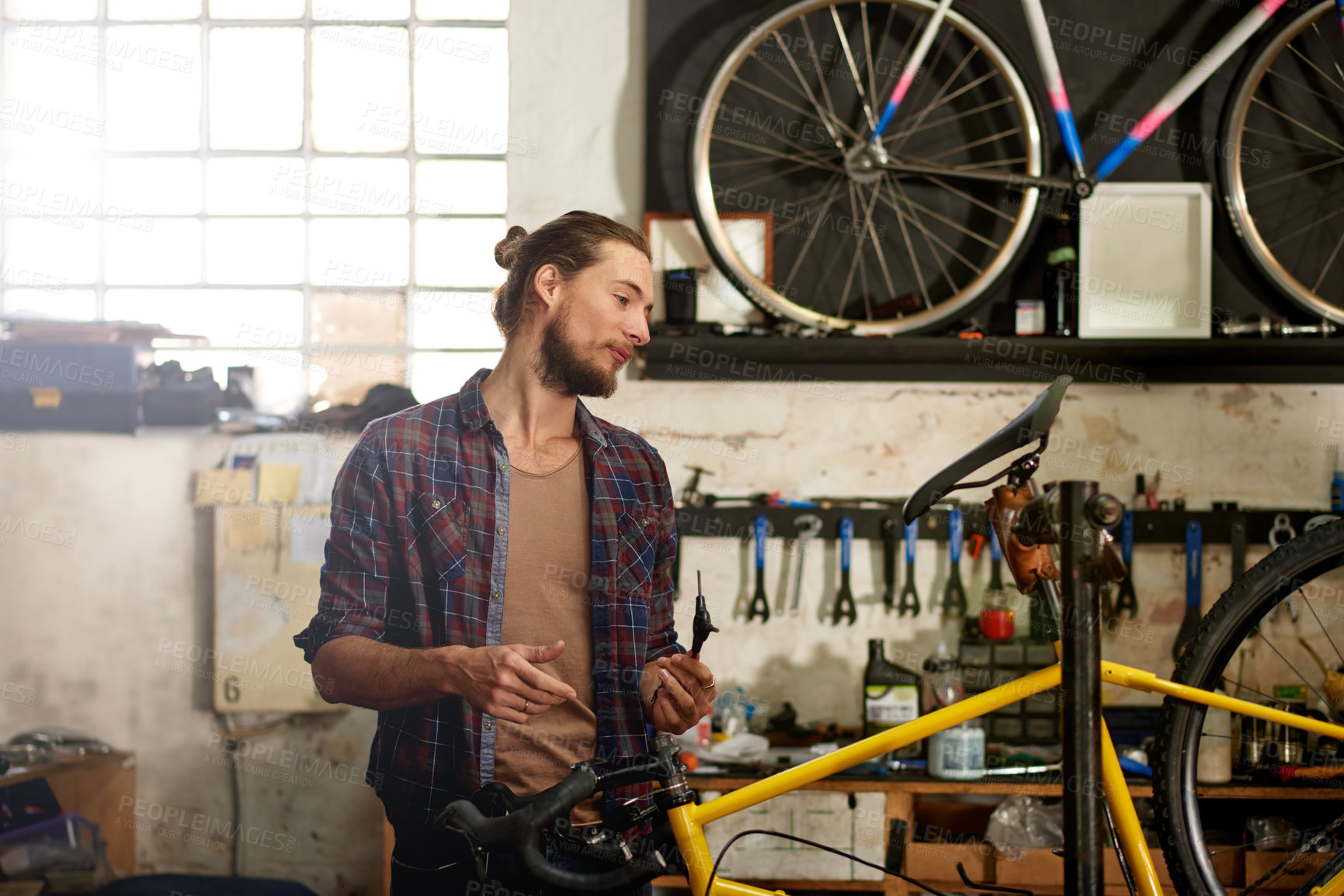 Buy stock photo Thinking, technician and man with bicycle, maintenance and repairing eco friendly transport at shop. Fixing, bike and person with ideas for service, reflection and entrepreneur with tools in store