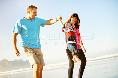 Buy stock photo Playing, swing and parents with child at beach for childhood, bonding and fun outdoor on holiday. Family, people and playful dad, mom and kid by ocean for holding hands, vacation or weekend in nature