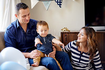 Buy stock photo Birthday, celebration and family with child, lounge or together for event in home, love and bonding. Parents, care or balloon decor for first party, mom and dad with son in house, people and presents