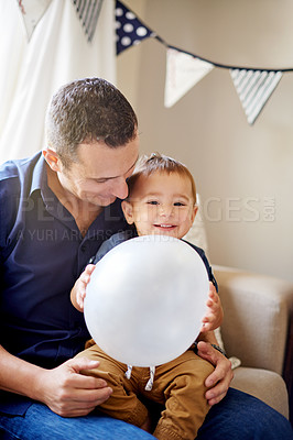 Buy stock photo Balloon, birthday or celebration with father and son on sofa in living room of home for milestone. Excited, happy or hug with boy child and single parent man in apartment together for bonding or fun