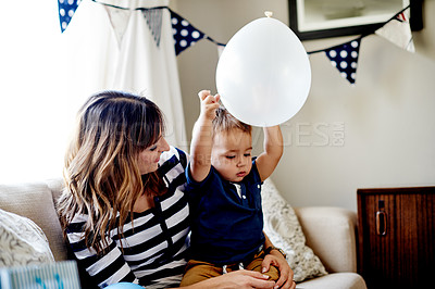 Buy stock photo Mother, toddler and balloons in living room for party with celebration, milestone and together in home. Woman, child and playing decorations for birthday event with love, care and fun in family house