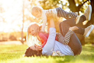 Buy stock photo Lifting, children and woman in nature, laugh or playing on summer holiday, bonding and fun on break. Bokeh, flare and mom with kids on weekend, happy and love for daughters, outdoor and together