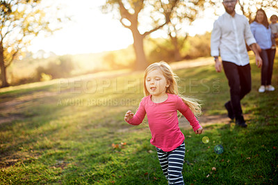 Buy stock photo Girl, child or running with parents in nature for fun childhood or playing on grass field. People, mom or dad with daughter or playful kid in sunshine for holiday, weekend or bonding together in park
