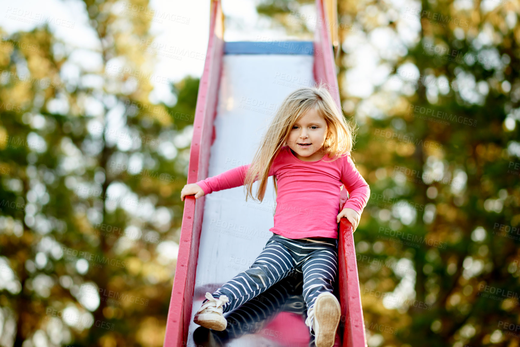 Buy stock photo Nature, playground and kid on slide for fun with development, growth or adventure by outdoor trees. Smile, brave and girl child for playing in park for learning with balance on summer holiday.