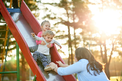 Buy stock photo Happy, slide and mom with children, playground or bonding with daughters on weekend, love or outdoor. Park, woman and smile with toddler in nature, growth and development of girls, family and care