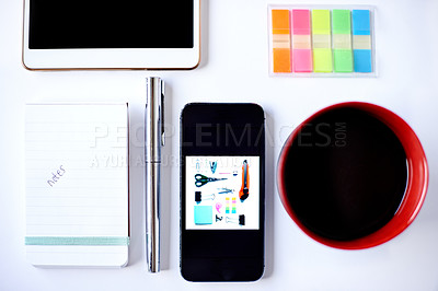 Buy stock photo Tablet, stationery and notes with phone in studio for coffee, reminder and planning career. White background, beverage and notebook with digital technology for business, creative workplace or job