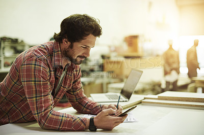 Buy stock photo Man, reading and phone in carpentry workshop for trade, stock and supply chain. Craftsmanship, research or artisan planning with mobile in warehouse for notes, project checklist and small business