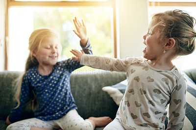 Buy stock photo Excited, high five and sofa with girl children in home together for bonding, celebration or fun. Energy, game and love with sister kids in apartment for playful achievement, motivation or success