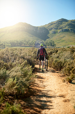 Buy stock photo Back, nature and man walking by bicycle for fitness, journey and tired on outdoor adventure. Athlete, bike and travel on mountain path for exercise break, wellness and catching breath for sports