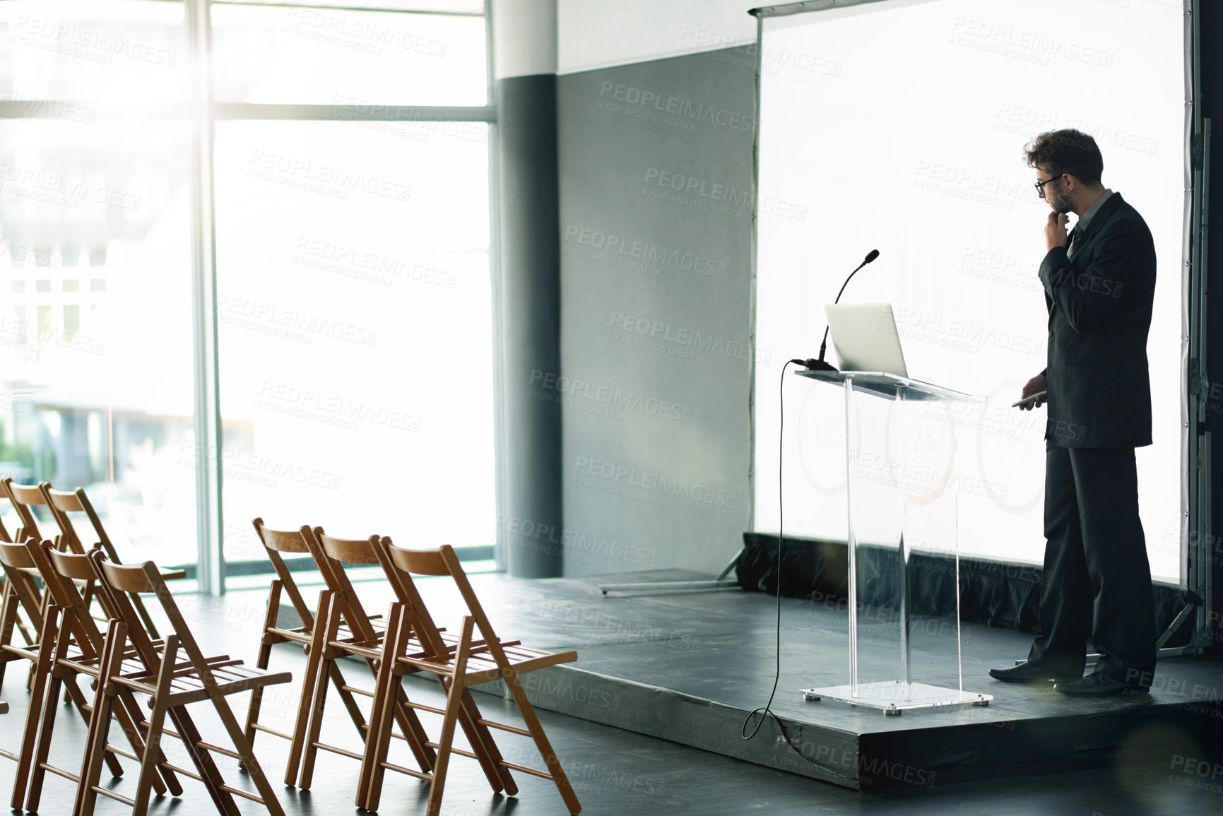 Buy stock photo Businessman, thinking and preparation with presentation on podium for workshop training on space. Thoughtful, man or speaker getting ready with laptop or projector for staff convention in workplace