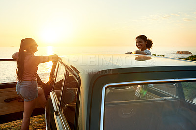 Buy stock photo Shot of two young women enjoying a road trip