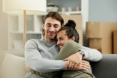 Buy stock photo New home, excited and couple hug on sofa to relax for moving, relocation or real estate purchase. Homeowners, bonding and man with woman with embrace, love and happy for property, mortgage or house