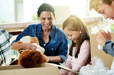 Buy stock photo Moving, boxes and mother with children for packing in new home with sorting toys for donation or charity. Cardboard, fun and mom helping kids with teddy bear or trinkets for relocation in house.