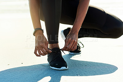 Buy stock photo Woman, fitness and tying shoes with hands for workout preparation, exercise or training run. Closeup, active or runner getting ready with sneaker or tie for balance, safety or warm up on beach sand