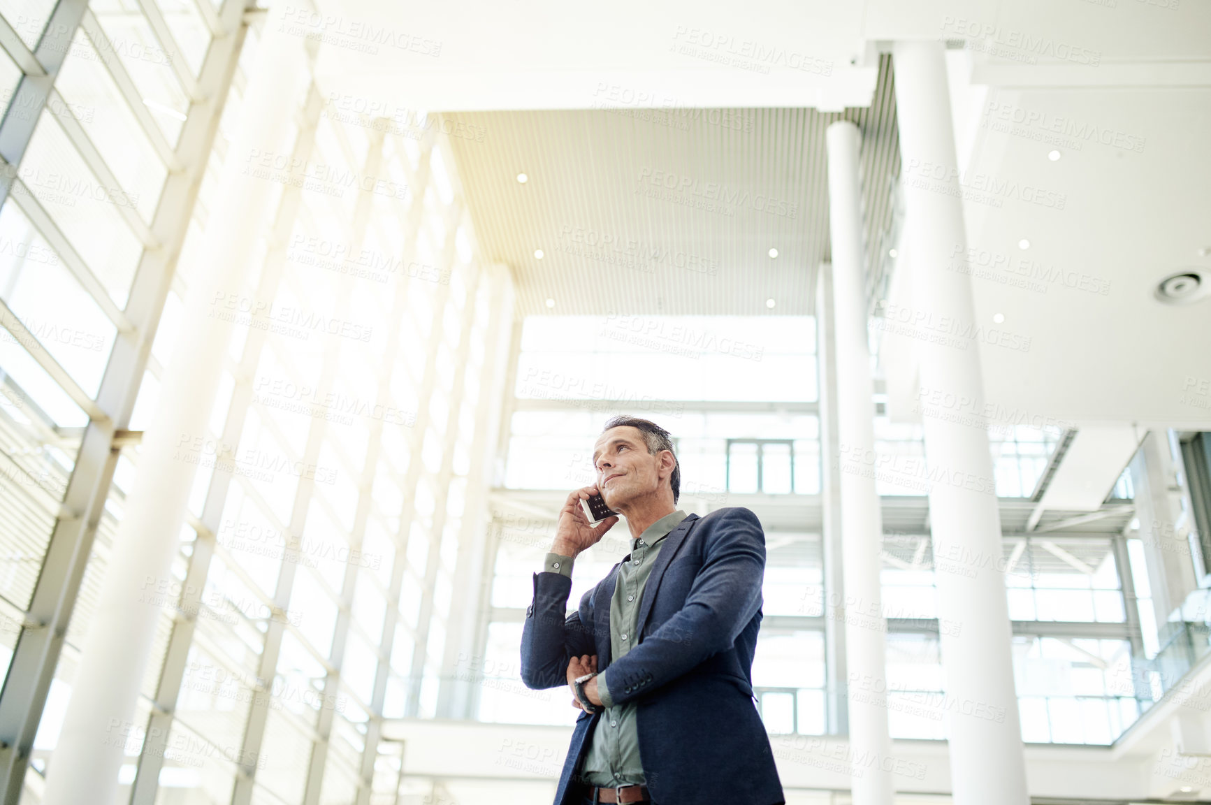 Buy stock photo Man, phone call and talk for real estate deal in lobby, low angle and contact for negotiation. Person, realtor and smartphone with discussion for property portfolio expansion, investing or agreement