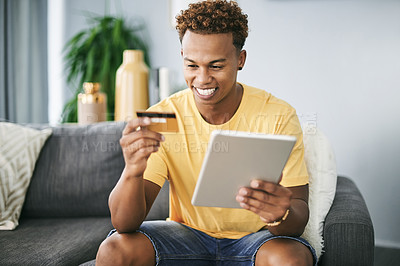 Buy stock photo Happy, man and tablet with credit card in home for online shopping, gaming subscription or checkout. Fintech, african person and smile with tech on sofa for internet banking, discount payment or sale