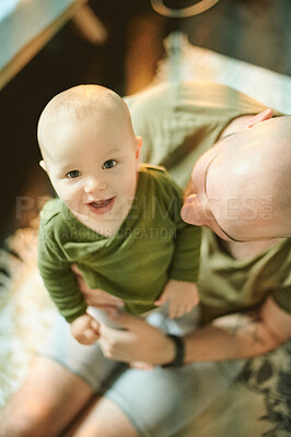 Buy stock photo Portrait, baby or family with a boy and his father bonding together in their home from above. Face, kids and love with a male infant in the arms of his papa while sitting in the living room