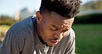 Fitness, exercise and male runner rest outdoor for fatigue, tired and break on run in park. Breathe, exhausted and black man with healthy lifestyle, training and cardio workout for wellness
