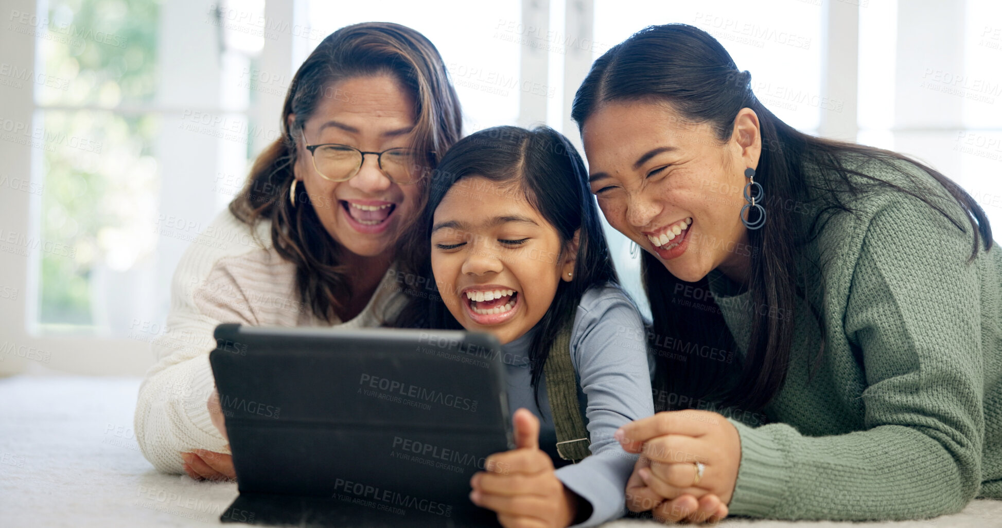 Buy stock photo Laugh, relax and tablet with women in family home for streaming service, parental control and happy. Age rating movie, support and generations with grandmother, kid and mother in house for comedy