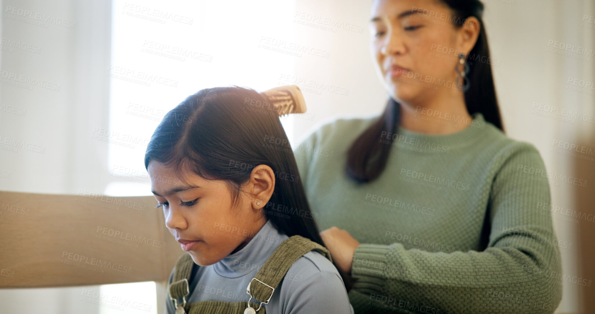 Buy stock photo Child, mother and brush for hair care in home, grooming and help daughter in morning routine. Parent, girl and hairstyle assistance with Asian family, beauty support and bonding together with love
