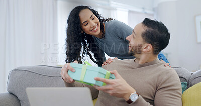 Buy stock photo Couple, surprise and gift giving in home with smile for birthday celebration, care or appreciation. Wow, present and happy people on sofa for connection, gratitude and love on special day with laptop