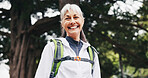 Hiking, happy and senior woman in nature for trekking, fitness and exercise for wellness on weekend. Portrait, mountain and person with smile for adventure, backpacking and travel outdoor for health