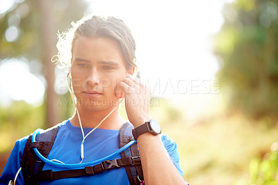 Buy stock photo Hiking, music and relax with man in nature for workout playlist, streaming and adventure. Wellness, trekking and fitness with person and listening with earphones in forest for health, radio and walk