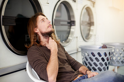 Buy stock photo Hygiene, man and cleaning clothes at laundromat, waiting and customer thinking of self service. Laundry shop, person and commercial washing machine for chores, housework and drying with reflection