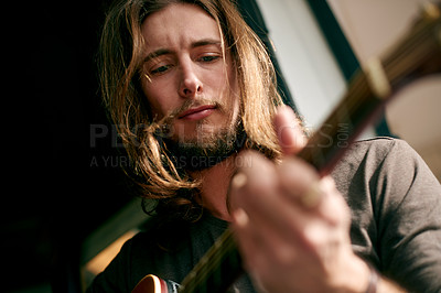 Buy stock photo Playing, music and man with guitar in home with tuning instrument, performance or practice. Artist, rehearsal and male person with acoustic strings for song with talent, hobby or activity from below.