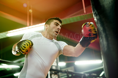 Buy stock photo Punching bag, fitness and man in gym for training, challenge or cardio activity for practice. Health, intense power and male athlete with boxing equipment for performance or exercise in sports center