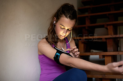 Buy stock photo Fitness, girl and phone pouch with earphones for music playlist, sync workout app or exercise podcast. Space, home and smartphone for listening to training audio, progress monitor and getting ready