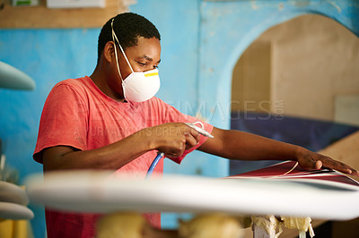 Buy stock photo Spray, black man and surfboard in workshop for fixing, restoration or manufacturing. Artistic production, paint or creative wooden craft in small business for surfing equipment or renovation process