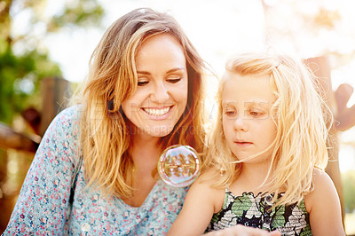 Buy stock photo Outdoor, bubble and mother with girl, game and bonding together with happiness. Family, parent and mama in backyard, child and daughter with smile, summer fun and liquid soap with break and relax